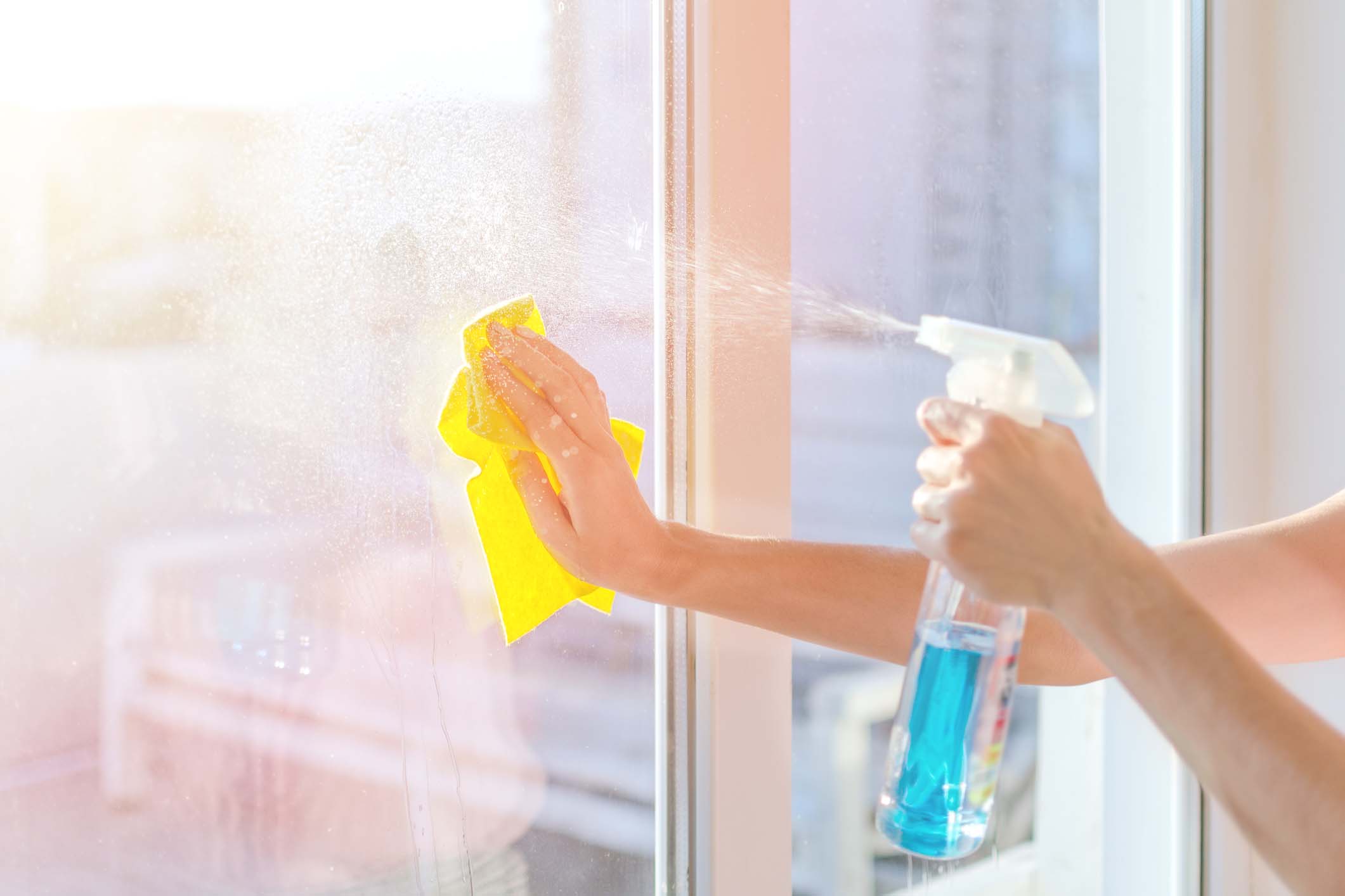 Hands with napkin cleaning window. Washing the glass on the windows with cleaning spray. Selective soft focus. Empty place for text, copy space. Window cleaning home